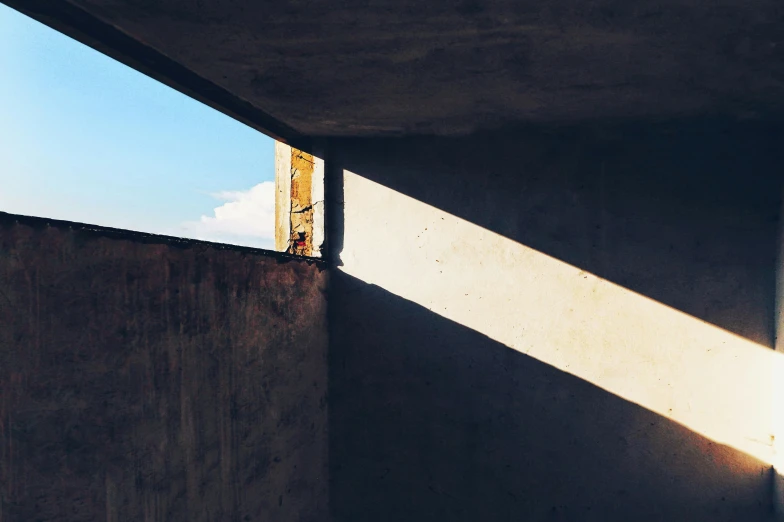 a view of the inside of a cement structure looking out at a building and sky