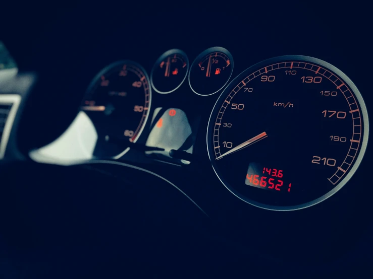 a car dashboard with an illuminated meter and vol time