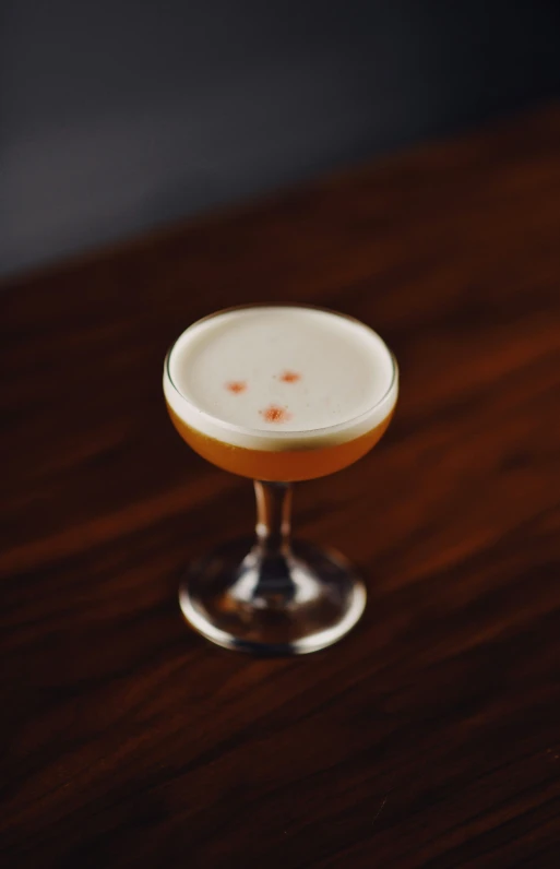 a cocktail sitting on a table with a lot of spots