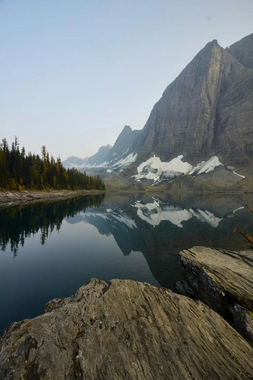 snow capped mountains loom above a small lake