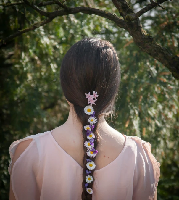 a woman wearing pink shirt with white flowers on her ponytail