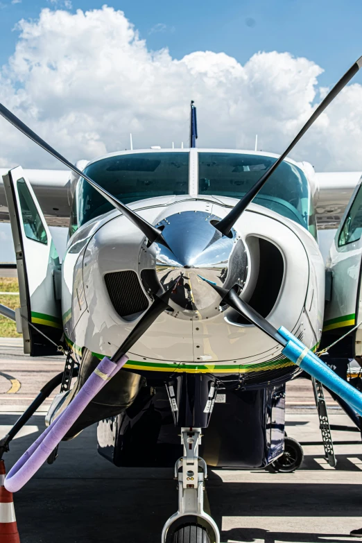 a white small airplane with propellers parked on the runway