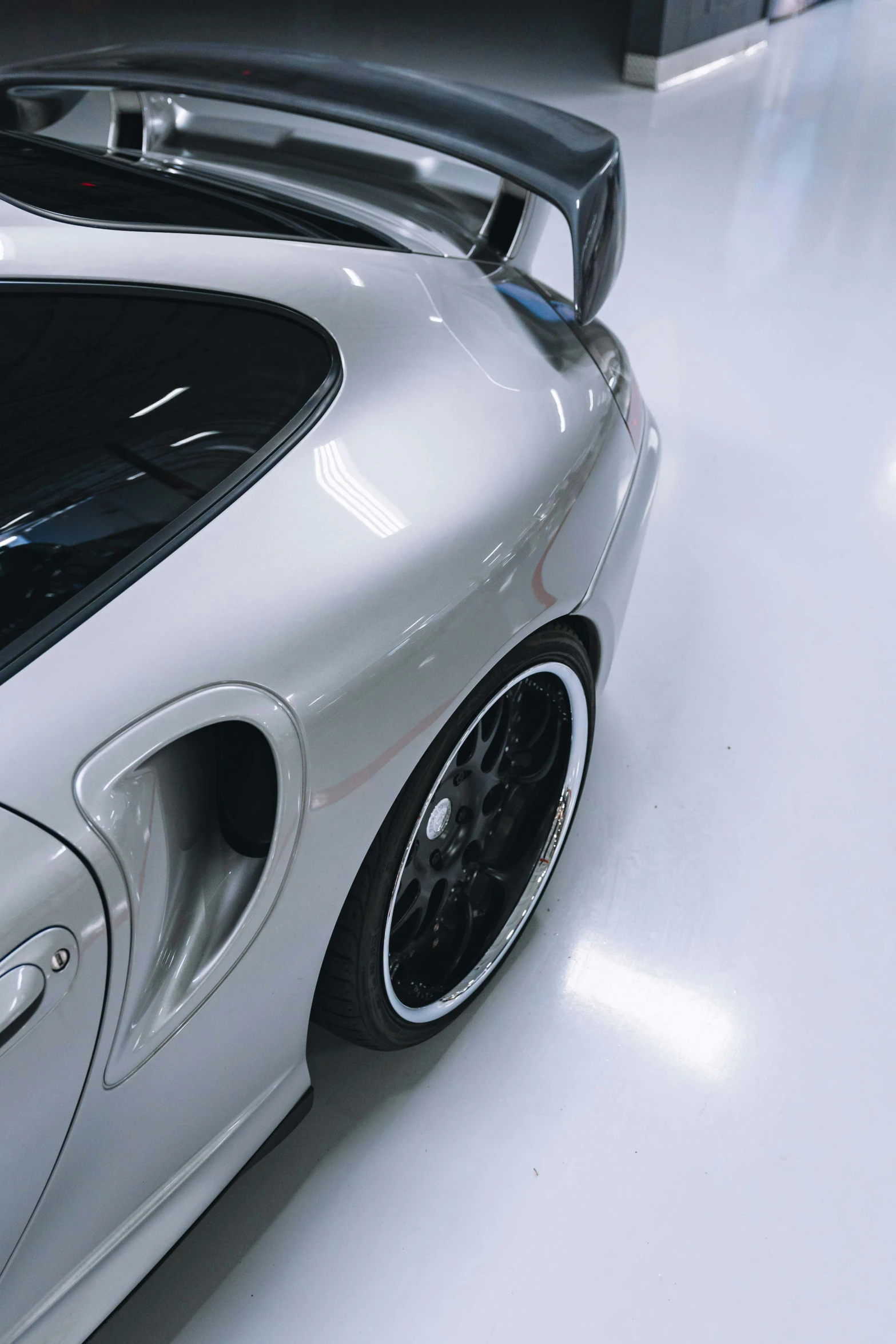 the rear end of a silver car parked in a garage