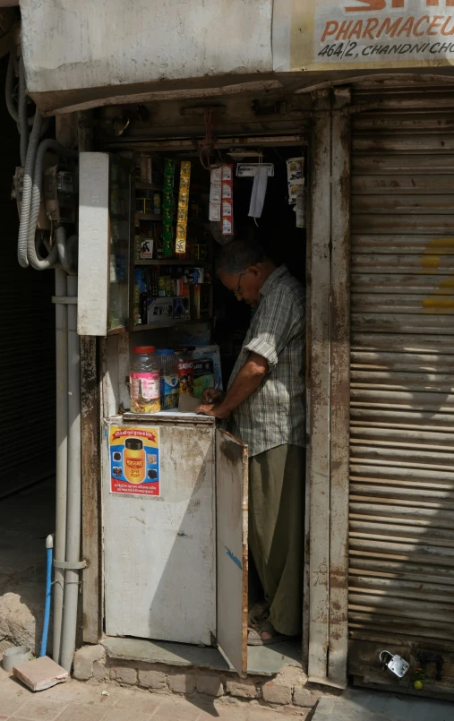 a man is looking inside a small icebox