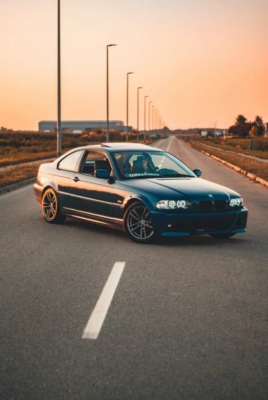 a blue car driving on the side of the road