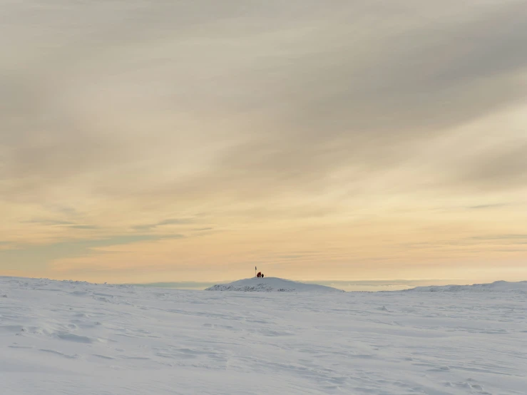 a person standing on top of a snow covered hill with a cross country ski slope