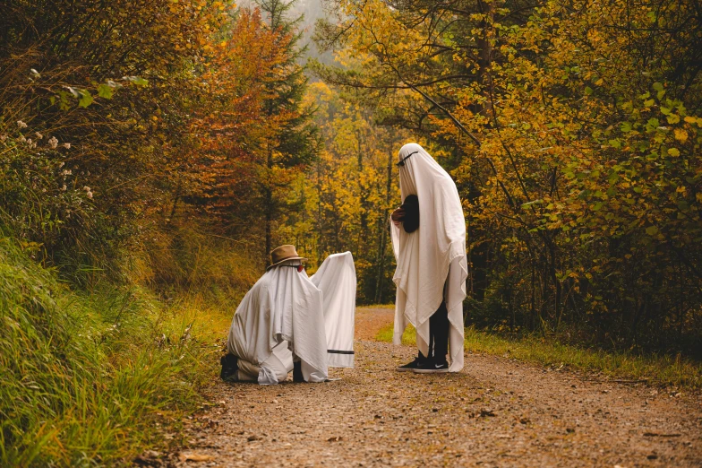 people are dressed up in white and sit on the gravel road