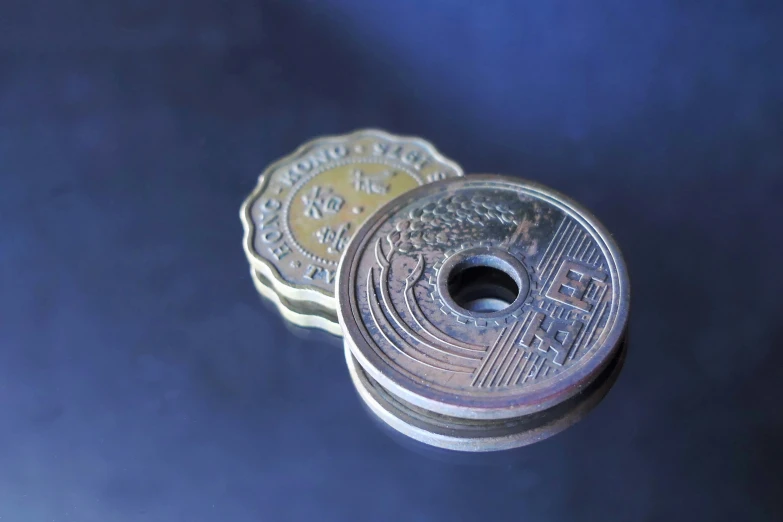 three round silver coin tokens sitting on top of each other