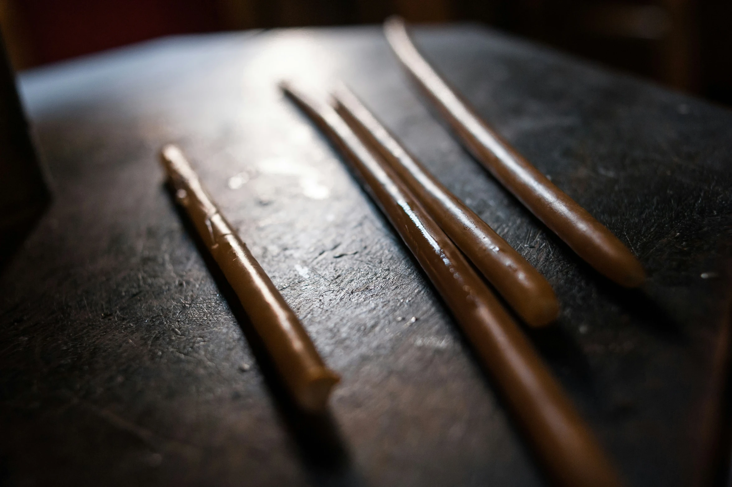 there are two sticks sitting on the table near a cup