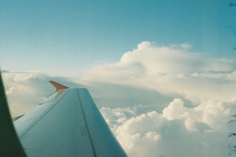 the wing and tail of an airplane flying high up in the sky