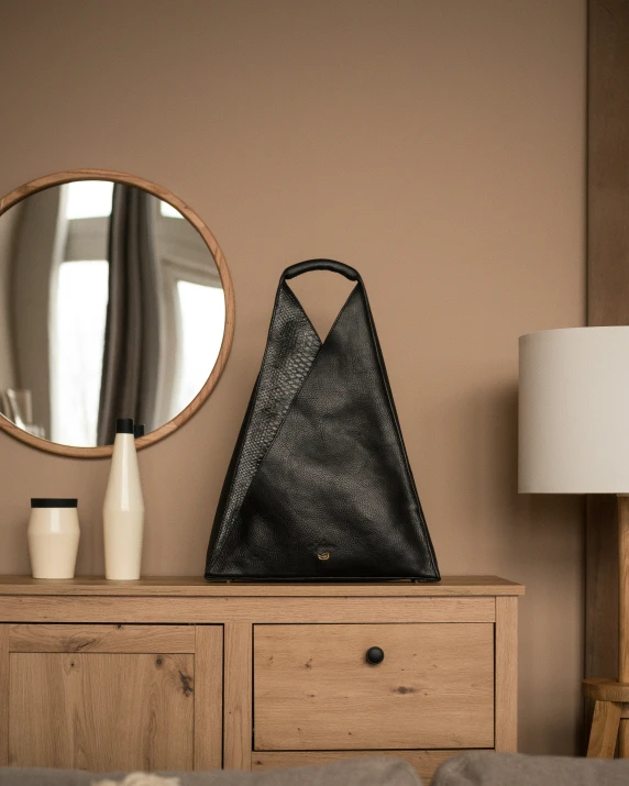 a purse sitting on a dresser with a mirror and a lamp