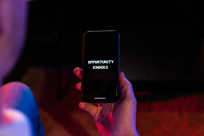 a person is holding up their cellphone while standing in front of the camera