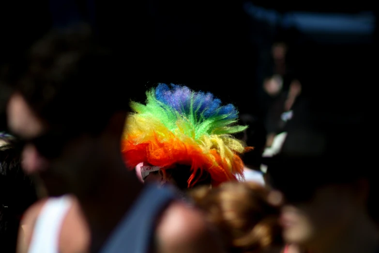 a colorfully dressed feathered hat on a lady's head