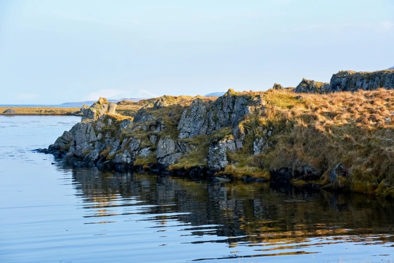 a rock outcropping on the edge of a large body of water