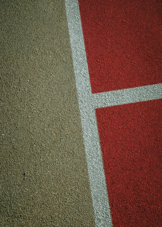 a tennis court with red and tan spots