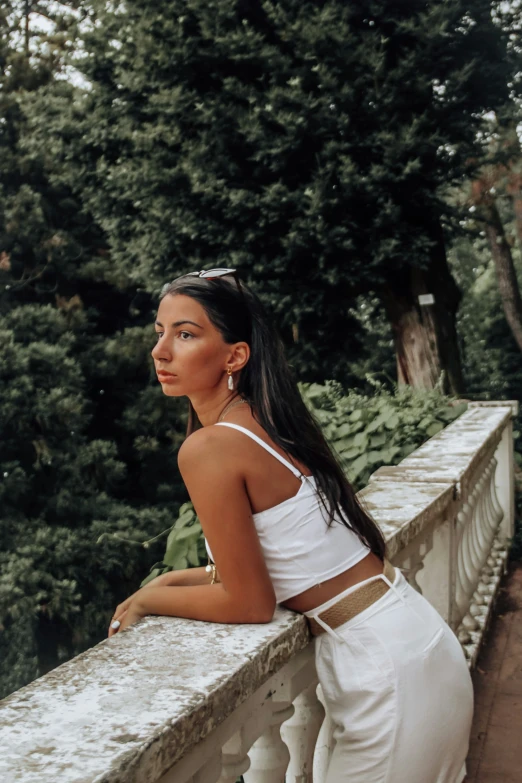 a woman sitting on the edge of a bridge