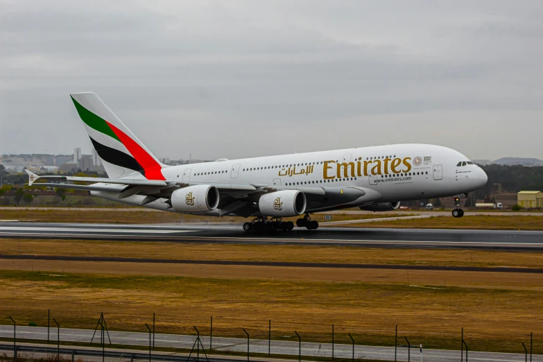an emirates airplane taking off from an airport runway