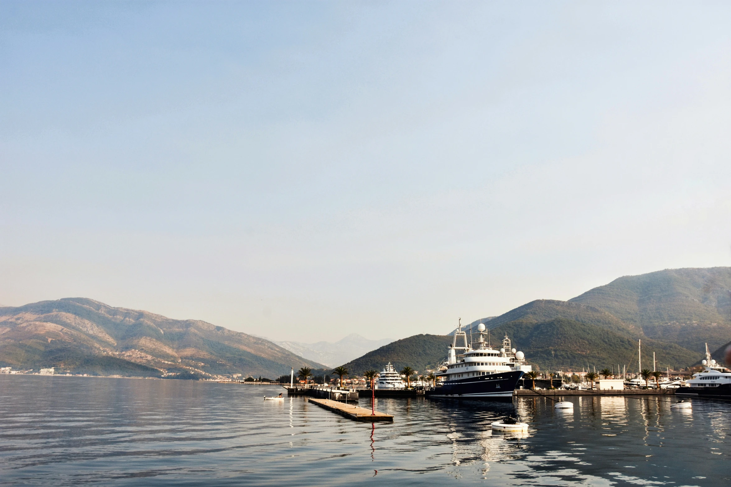 a harbor filled with a ship next to a mountains