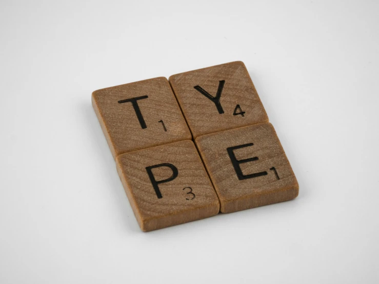 a wooden scrabbled type on white surface