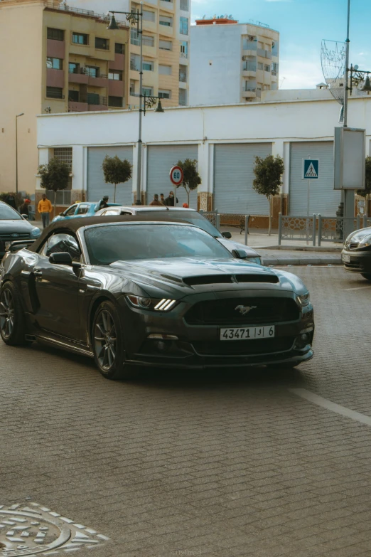 a black sports car on the road in front of some buildings