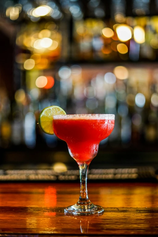 an alcohol filled margarita sits on the bar