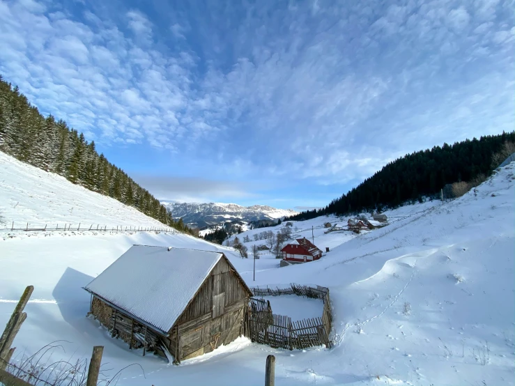 a house is surrounded by snow and trees on a mountain