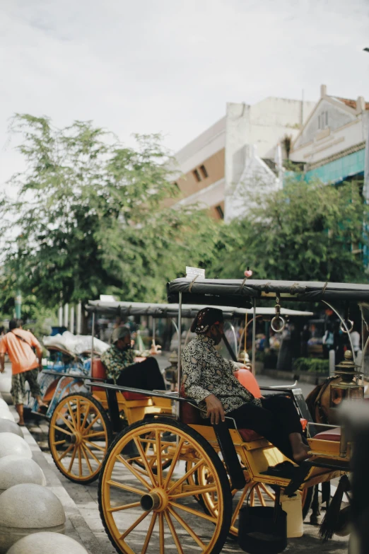 the person is sitting in an antique carriage