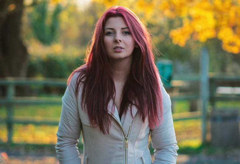 a girl with long red hair in an enclosure