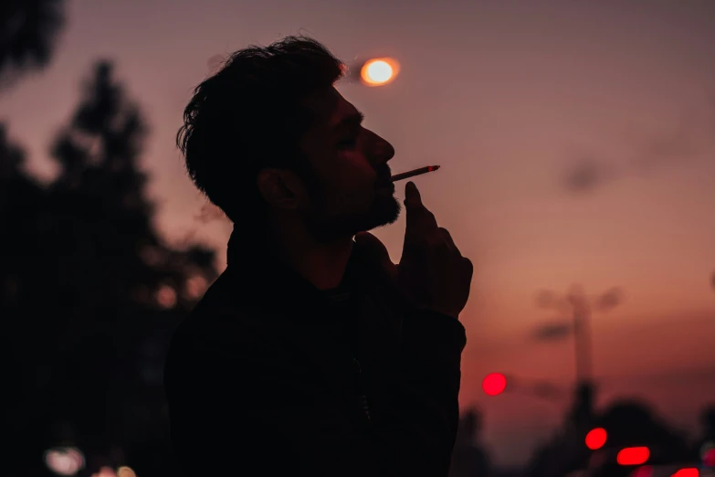 a person smoking soing with the sun setting in the background