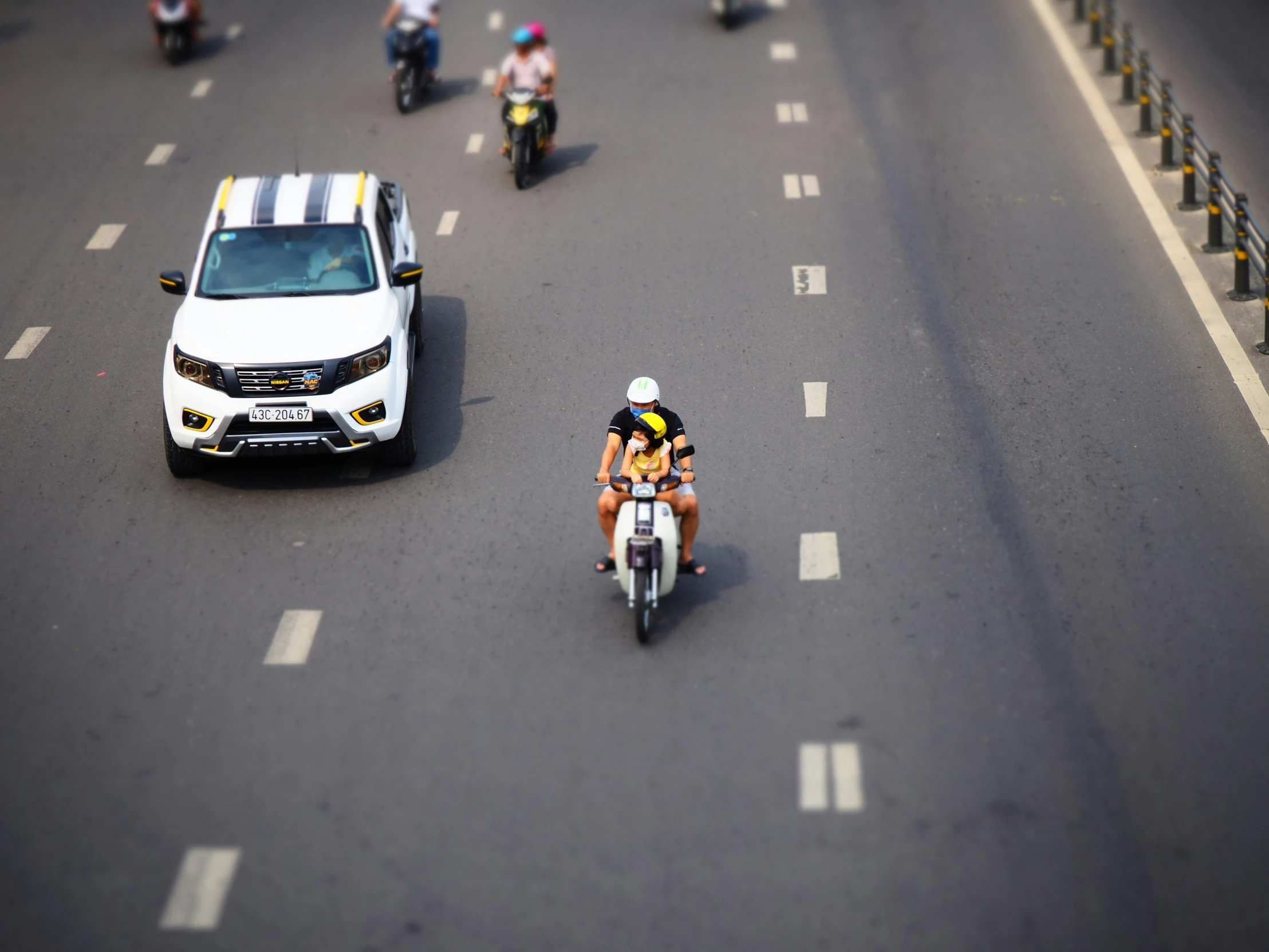 some motorcycles and cars and a couple people on the street