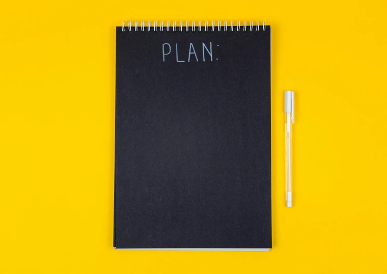 a notebook with the word plan written on it