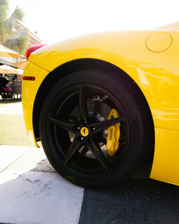 the yellow sports car has some black spokes