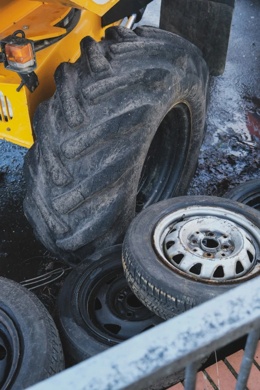 the wheels and tires of a yellow tractor parked in water