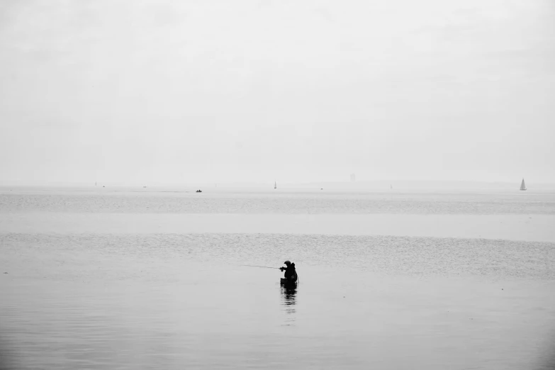 a man is standing in the water with a surfboard