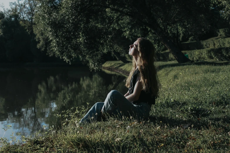 a woman that is sitting by some water