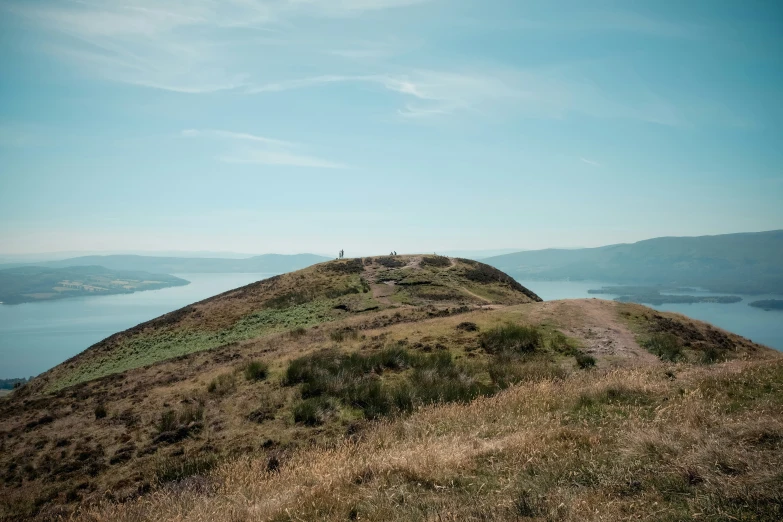 a small hill with two people standing on it