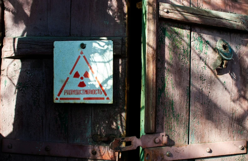 a wooden structure with a red triangle and a sign