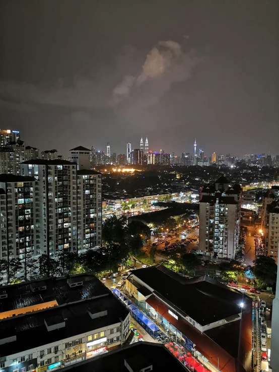 city lights shine brightly from the night sky above high rise buildings