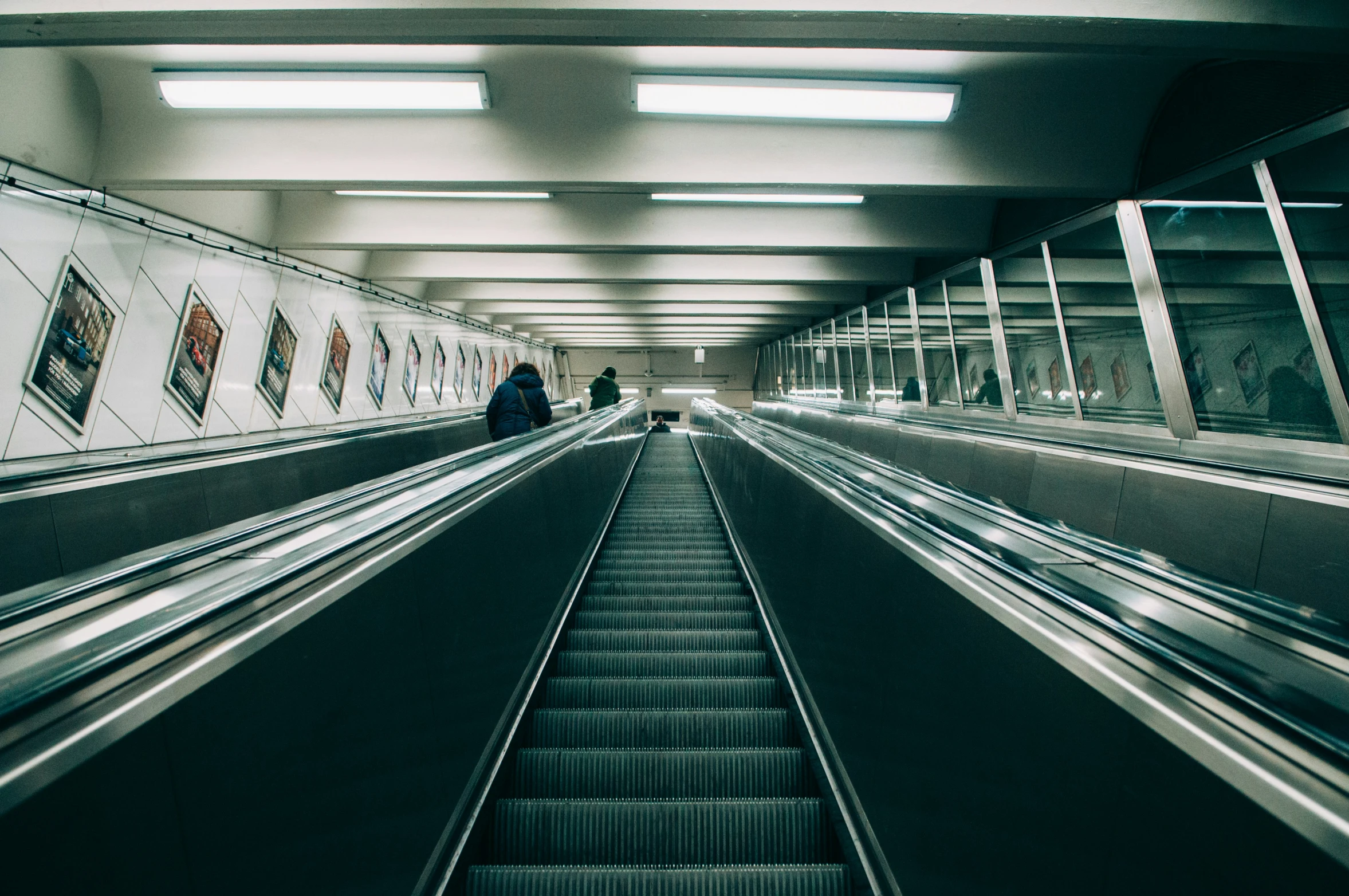 an escalator at a subway station with people walking