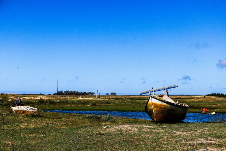 a boat in the grass by the water