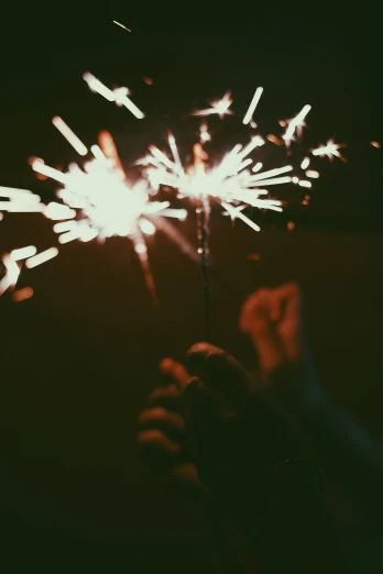 a person holding a small fireworks stick