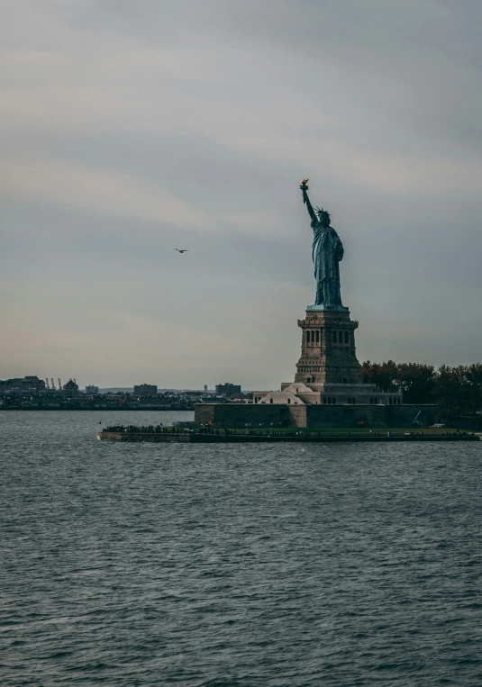 the statue is on a small island in the middle of the water