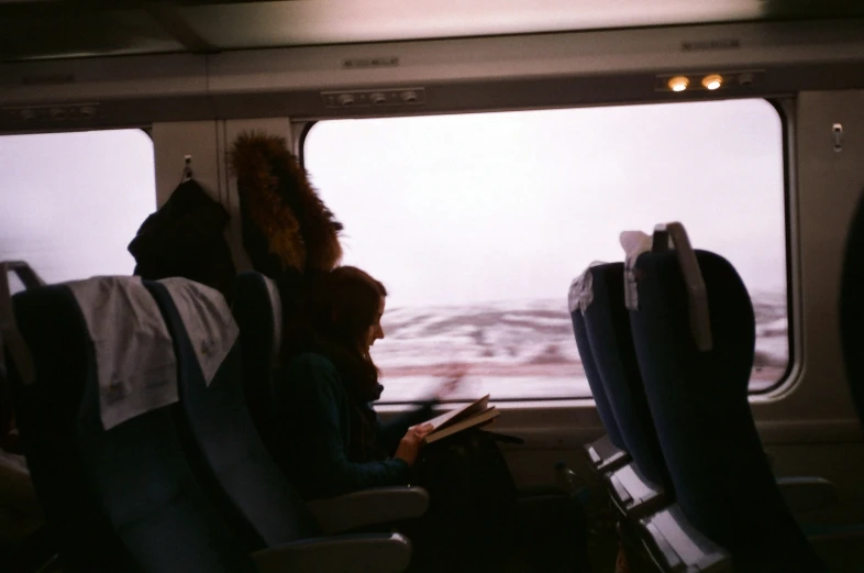 two people in seats looking out an airplane window