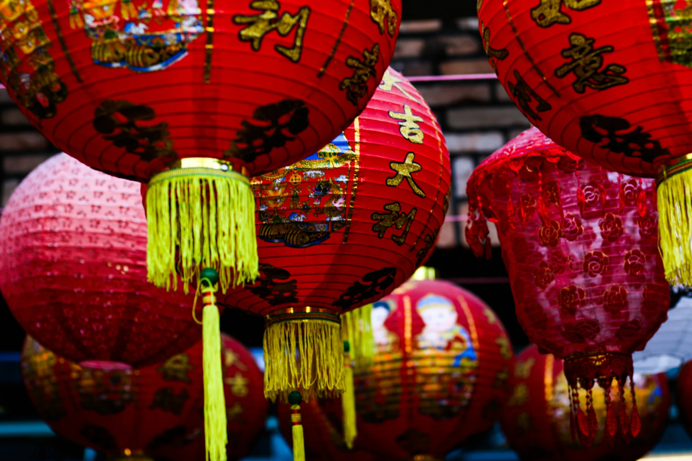 chinese lanterns in red and yellow hang over a street