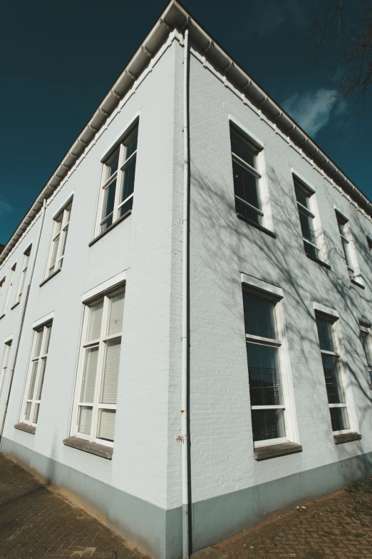 a large white building with several windows and three white shutters