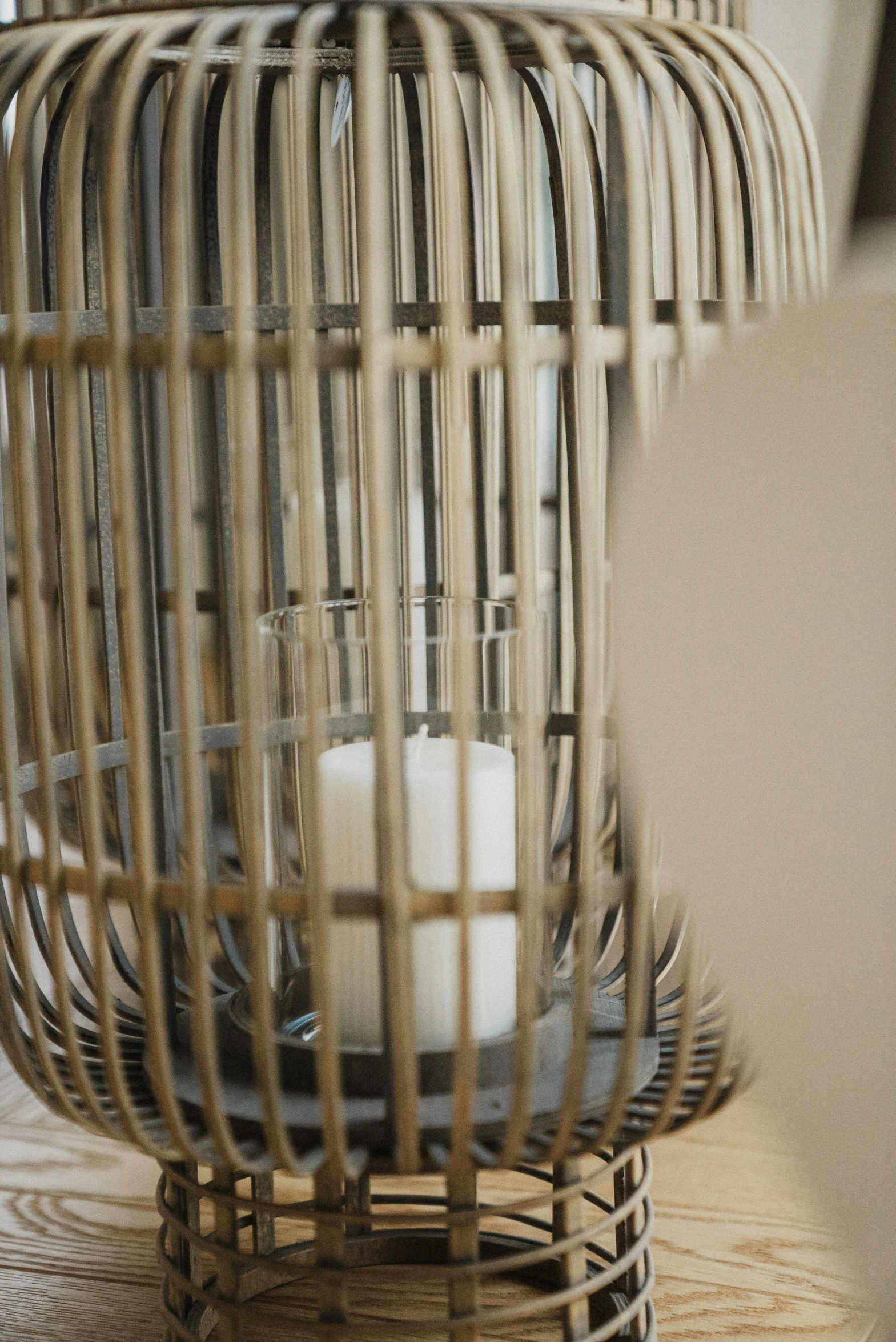 a bird cage with white candles inside of it