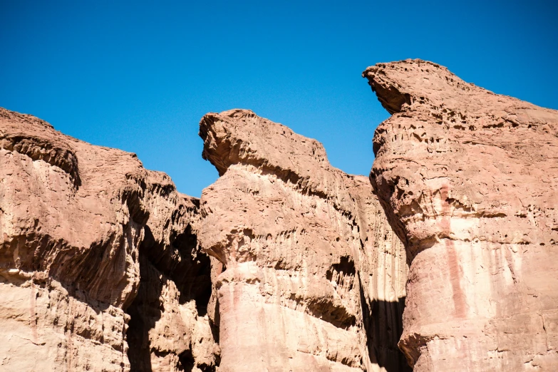two rock formations with a blue sky in the background
