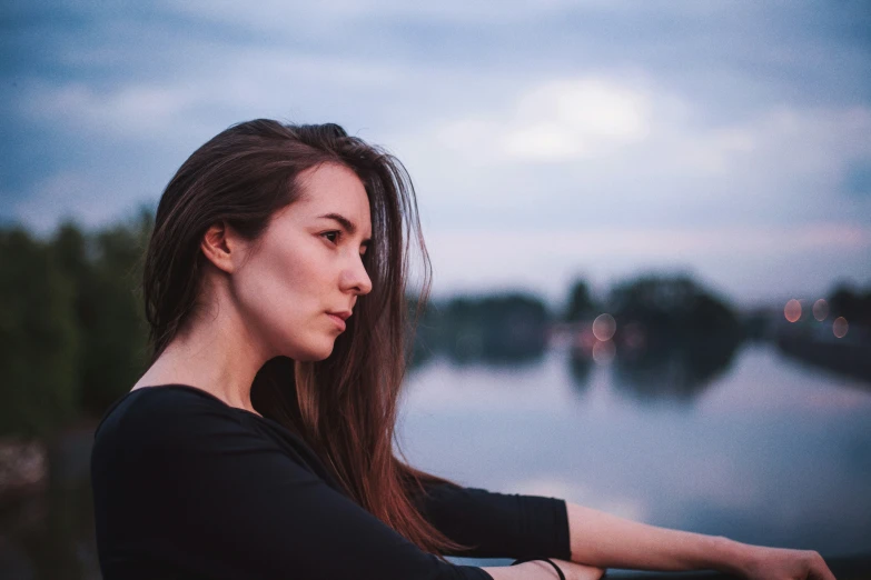 a girl staring away from the camera and standing outside