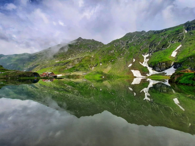 an alpine lake surrounded by tall green mountains