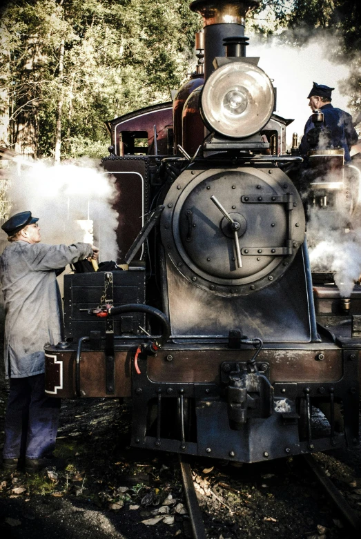 two men are standing on the front of a train engine